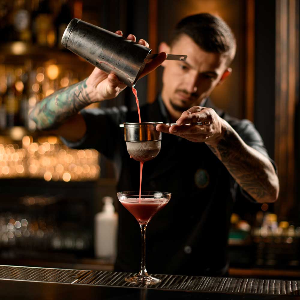 A bartender concentrating on mixing a drink